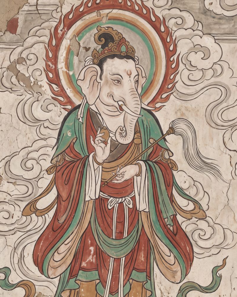 Mural-style painting of an elephant-headed deity in flowing red and green Chinese robes, standing inside a flame halo and holding a fly whisk